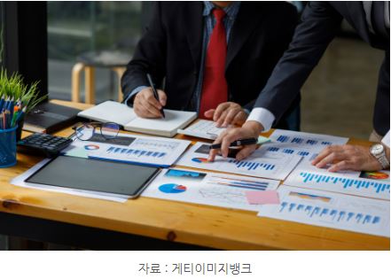 각종 투자 관련 그래프 자료를 보는 모습의 이미지.